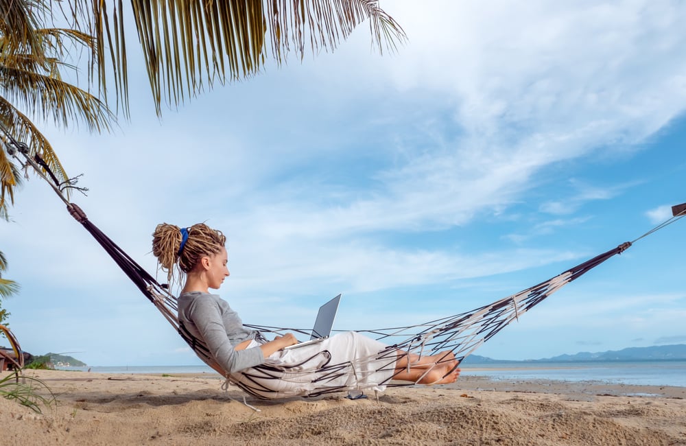 mulher com rede na praia com pc