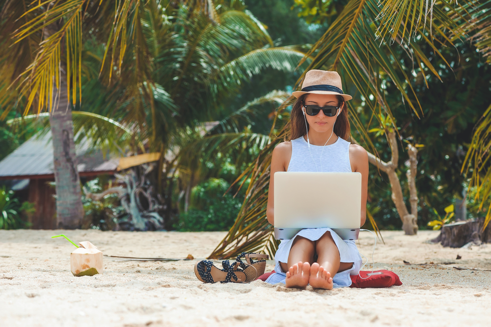 mulher com pc na praia