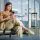 Mulher usando smartphone no terminal do aeroporto - app eDreams