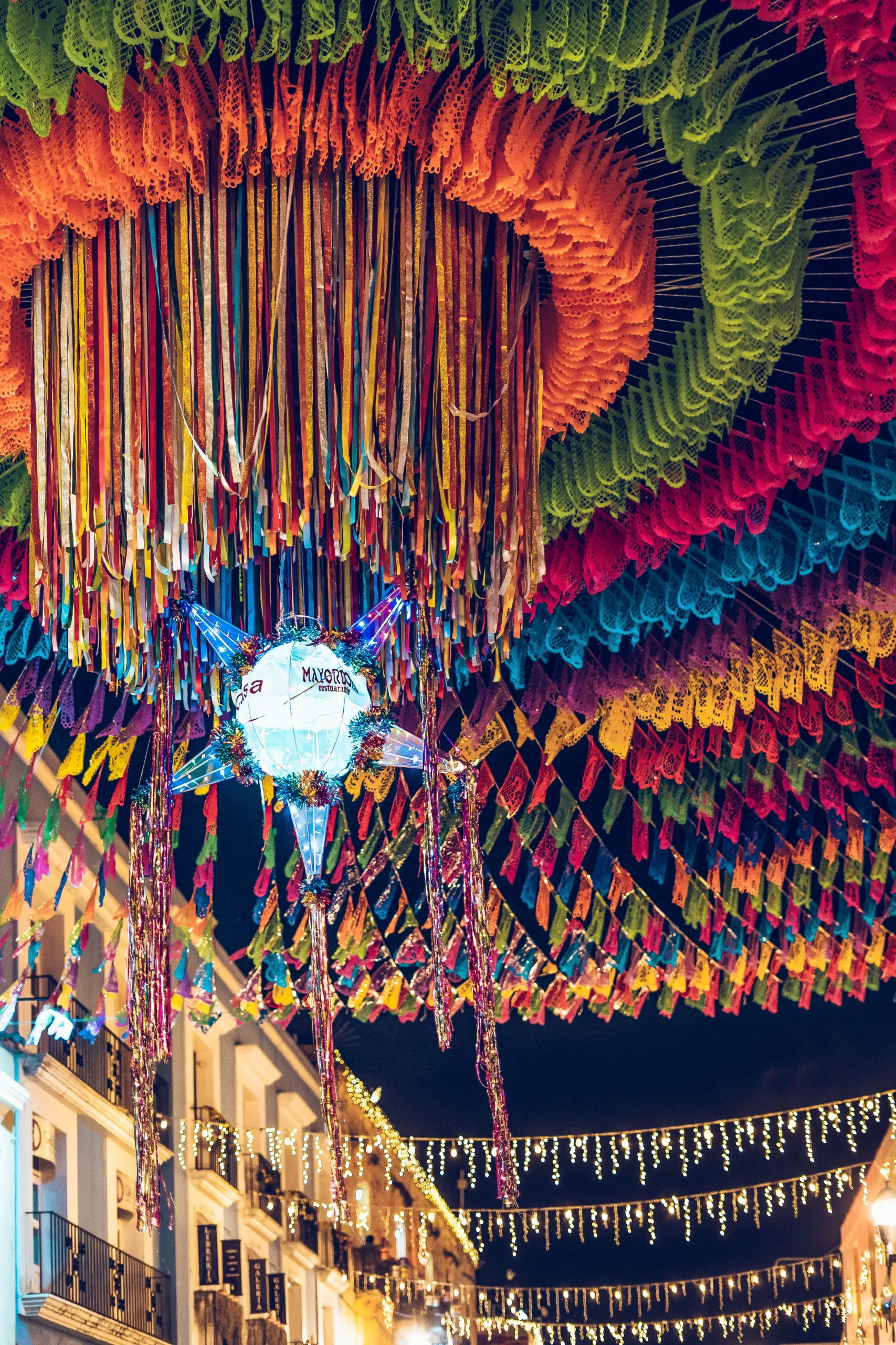 Decorações tradicionais de posada mexicana, com bandeirolas coloridas e piñata